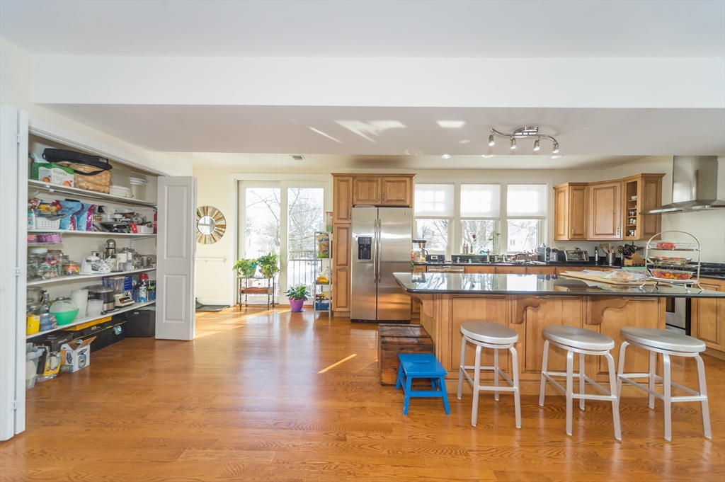 53 Winslow Road, Unit A Brookline, MA 02446 - Photo 8 of 16 a kitchen with stainless steel appliances a dining table chairs and view living room