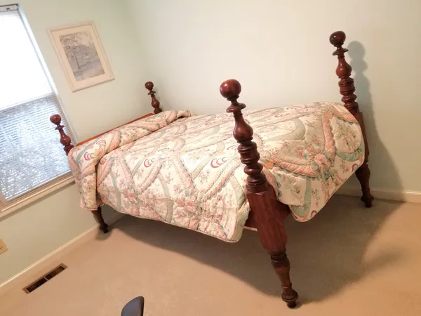 a bed sitting in a bedroom next to a window