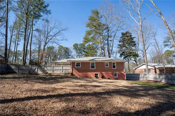 a view of a house with backyard and a tree