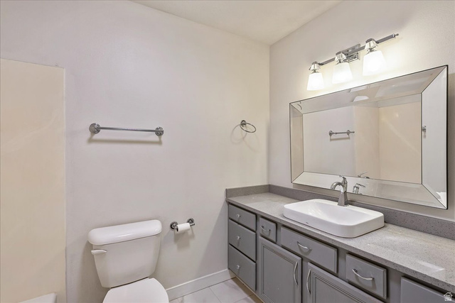 38 South 1000th Street East Payson, UT 84651 - Photo 16 of 19 Bathroom featuring a modern vessel sink, gray cabinetry with drawer and cabinet storage, a wide beveled mirror, and a three-light vanity fixture