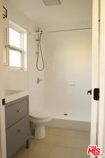 a bathroom with a granite countertop sink a toilet and shower