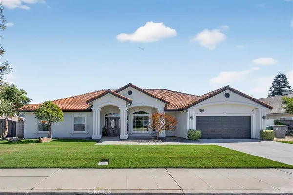a front view of a house with a garden and yard