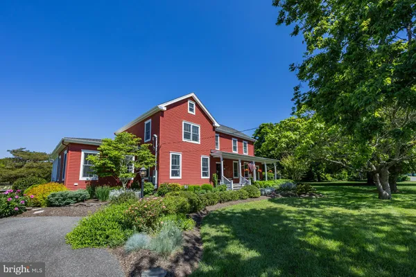 a view of a patio with couches table and chairs potted plants with wooden floor and fence
