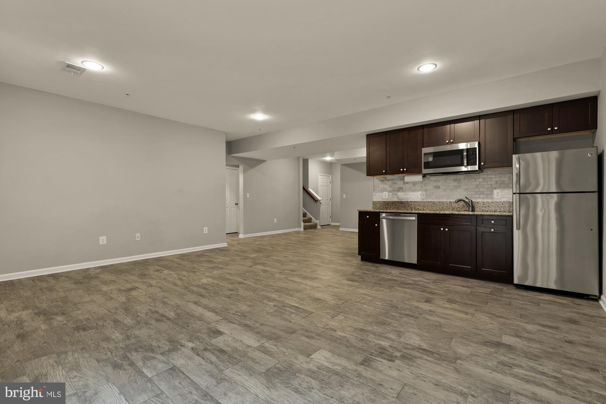 15611 Coolidge Avenue Silver Spring, MD 20906 - Photo 53 of 57 a view of kitchen with stainless steel appliances granite countertop a stove top oven a sink and dishwasher a refrigerator with wooden floor