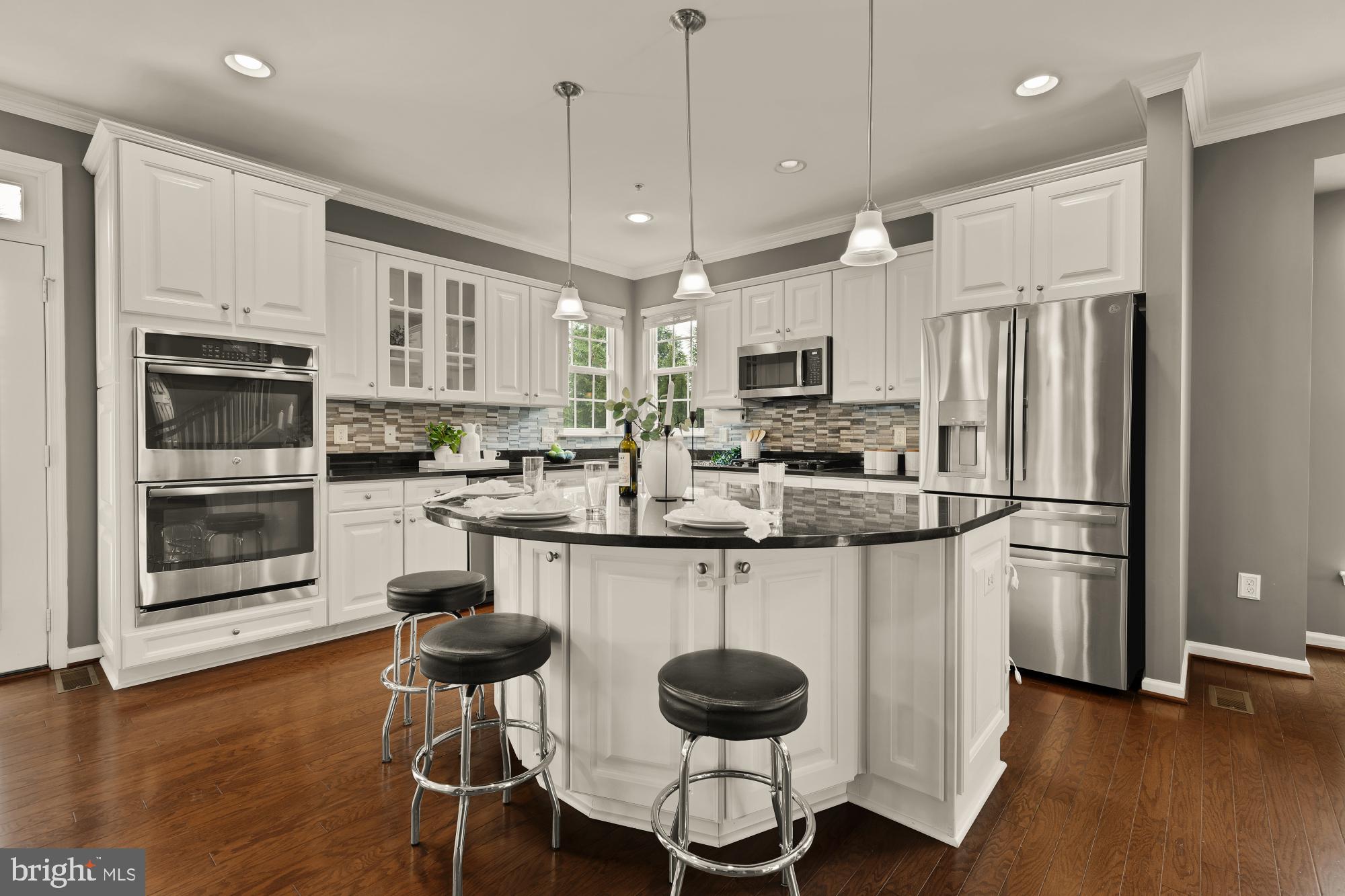 15611 Coolidge Avenue Silver Spring, MD 20906 - Photo 9 of 57 a kitchen with stainless steel appliances a stove top oven a refrigerator a sink and a dining table with wooden floor