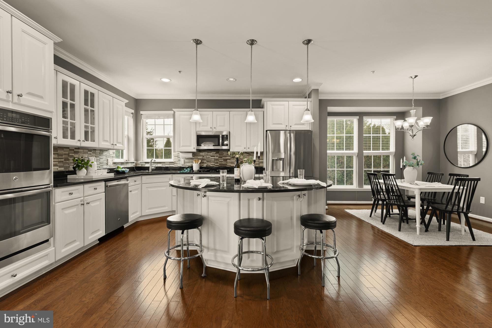 15611 Coolidge Avenue Silver Spring, MD 20906 - Photo 10 of 57 a kitchen with stainless steel appliances granite countertop a stove a refrigerator a kitchen island a dining table and chairs with wooden floor