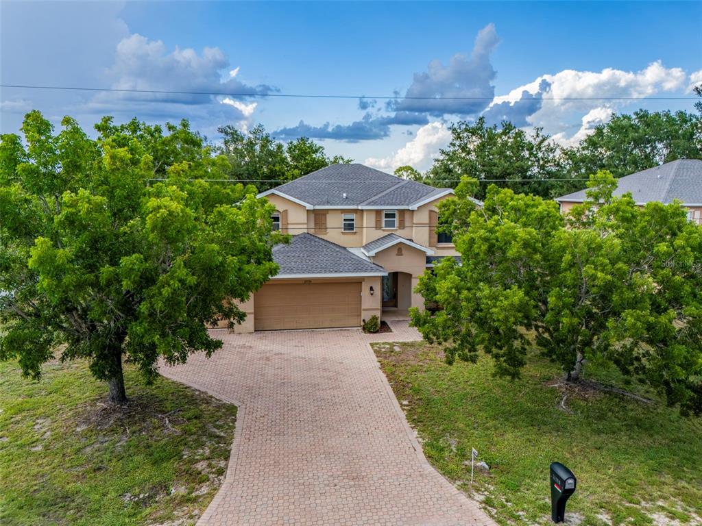 25134 Palisade Road Punta Gorda, FL 33983 - Photo 2 of 58 a front view of a house with a yard and large trees
