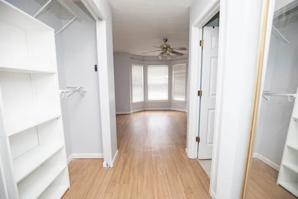 a view of a hallway with wooden floor and closet area