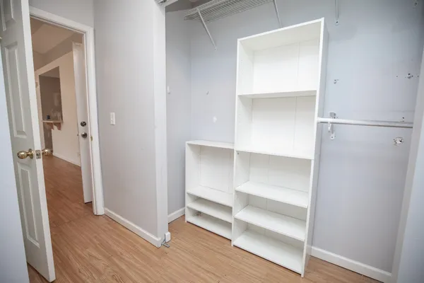 a view of walk in closet with empty racks