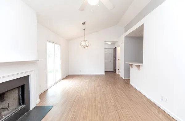 a view of a livingroom with wooden floor and a fireplace