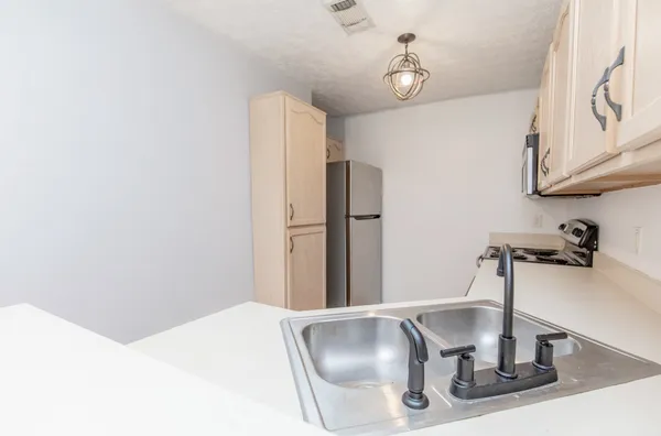 a kitchen with a sink and a refrigerator