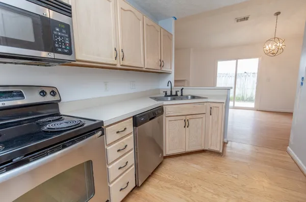 a kitchen with granite countertop a stove sink and cabinets