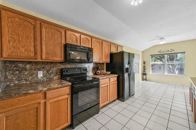 a kitchen with stainless steel appliances granite countertop a refrigerator oven a sink dishwasher and granite countertops with wooden floor