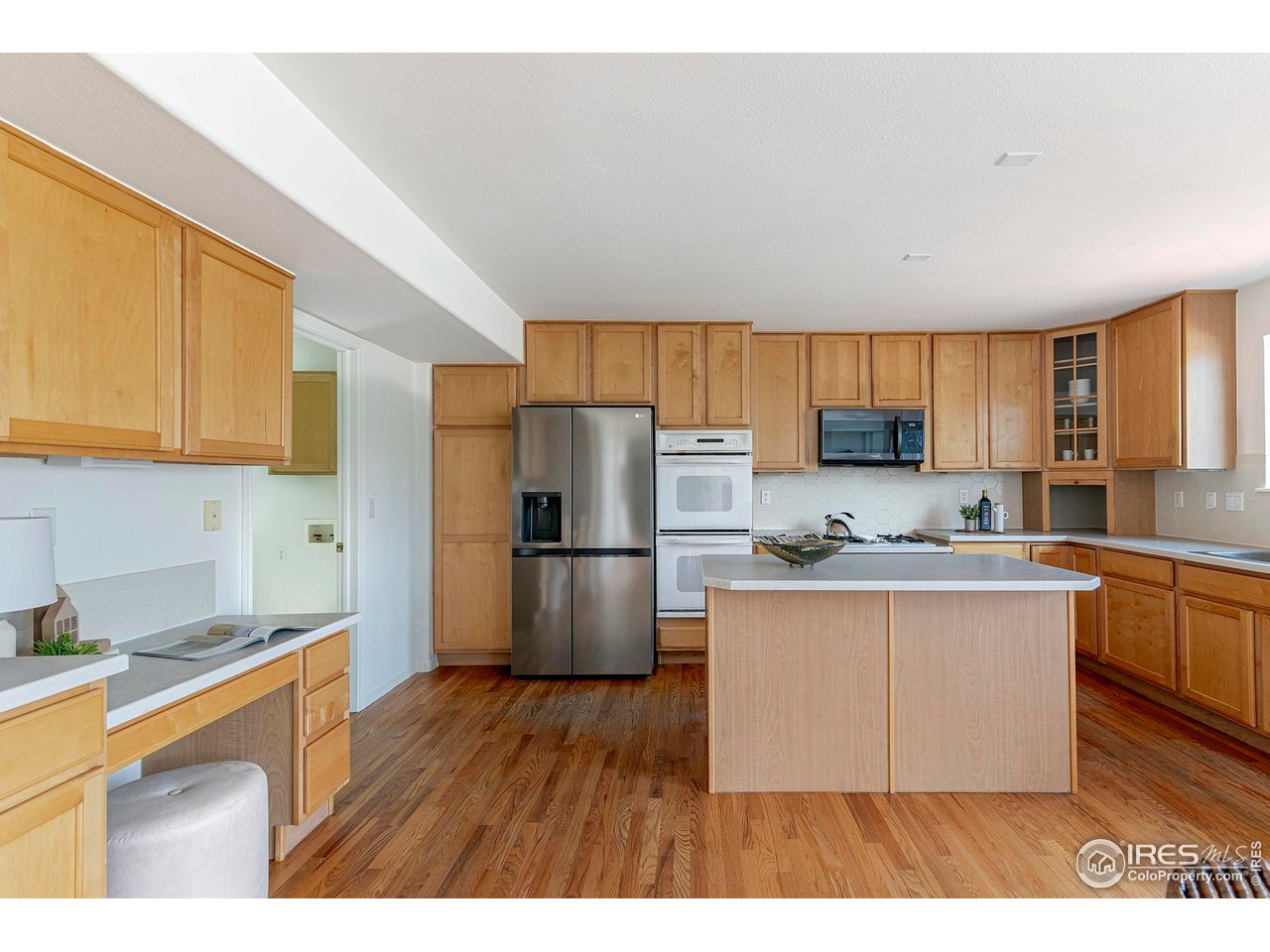 1414 Hoffman Drive Erie, CO 80516 - Photo 13 of 37 a kitchen with a refrigerator a stove top oven a sink dishwasher and wooden cabinets