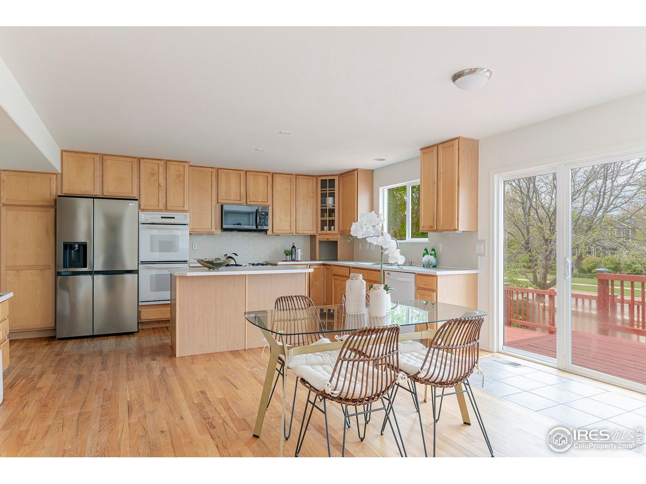 1414 Hoffman Drive Erie, CO 80516 - Photo 15 of 37 a kitchen with stainless steel appliances a refrigerator a stove a sink dishwasher and white cabinets with wooden floor