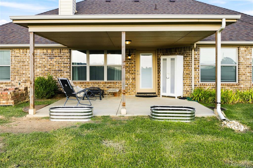 3911 Bennett Road Howe, TX 75459 - Photo 29 of 34 Made for relaxing in the morning or grilling burgers in the evening, this is a nice open covered space with a view of the big back yard.