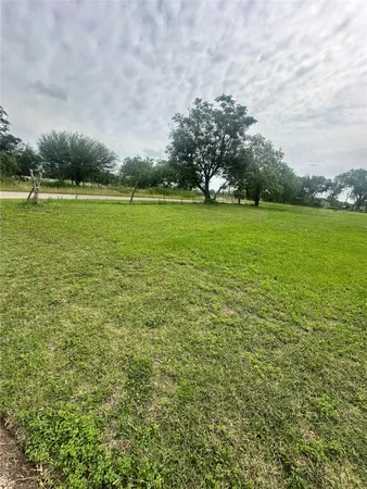 a view of a green field with wooden fence