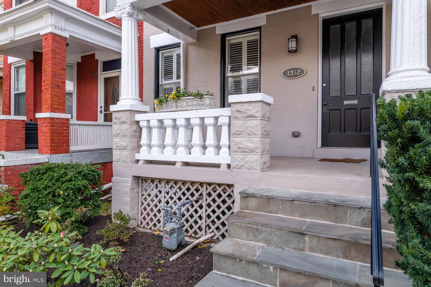 1352 Spring Road Northwest Washington, DC 20010 - Photo 3 of 14 front view of a house with a large window and wooden fence