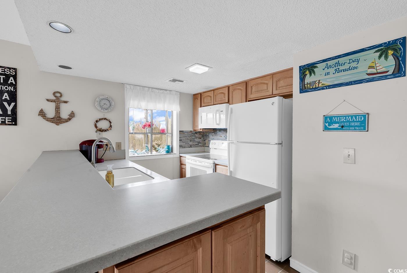 351 Lake Arrowhead Road, Unit 12347 Myrtle Beach, SC 29572 - Photo 4 of 36 Kitchen with a peninsula, white appliances, a sink