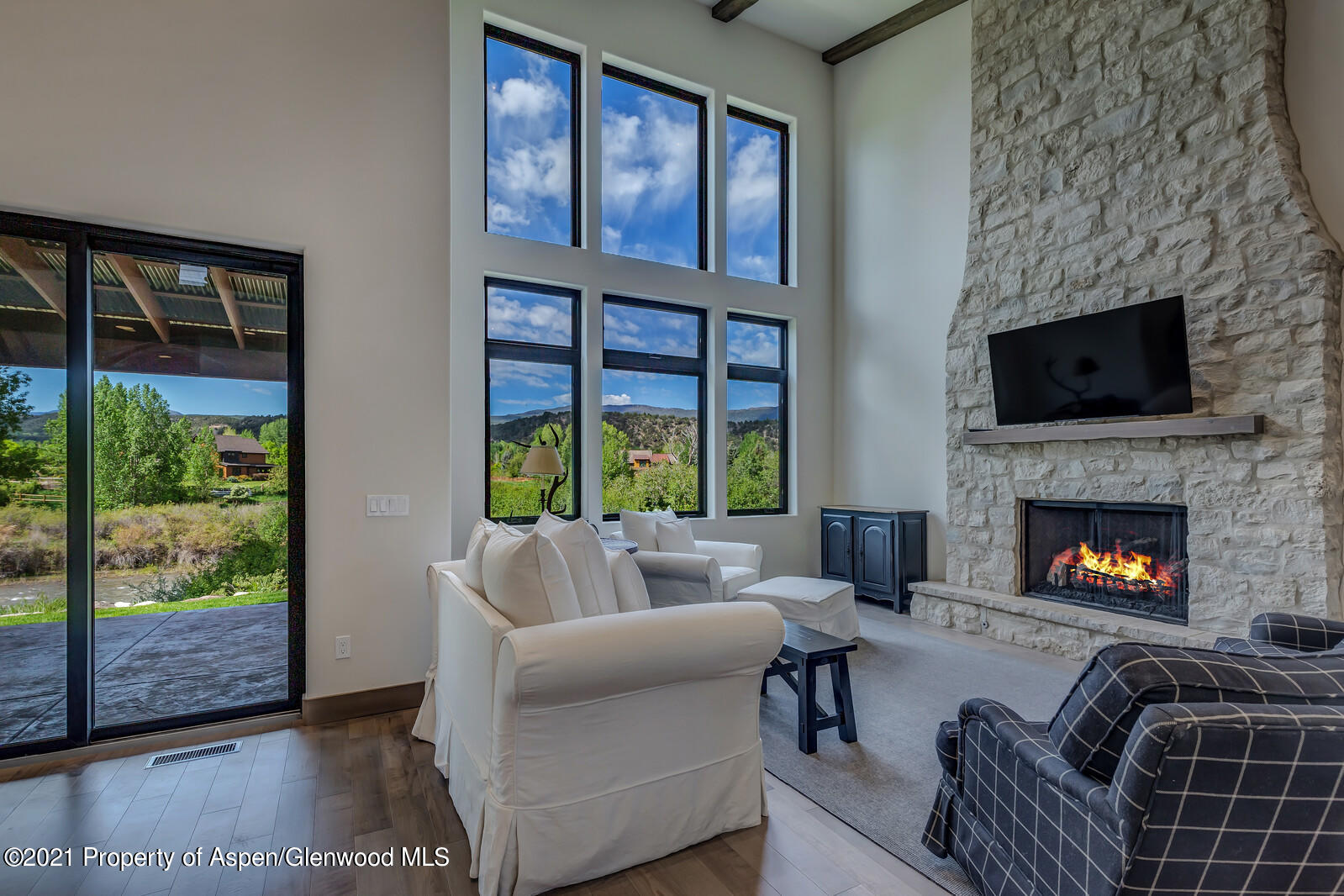 471 Boundary Lane Carbondale, CO 81623 - Photo 6 of 30 a living room with furniture a floor to ceiling window and a fireplace