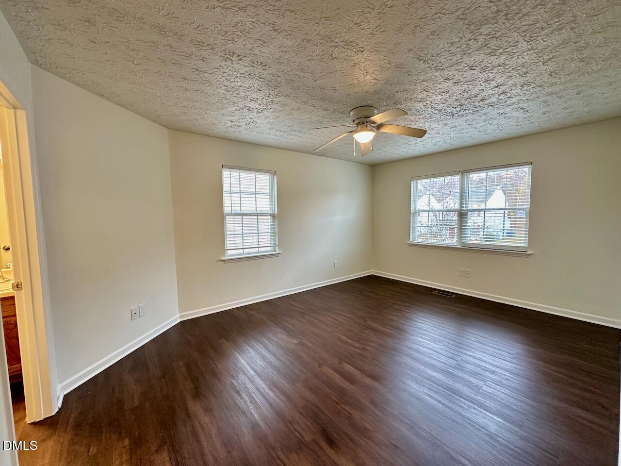 4232 Palafox Court Raleigh, NC 27604 - Photo 15 of 28 an empty room with wooden floor chandelier fan and windows