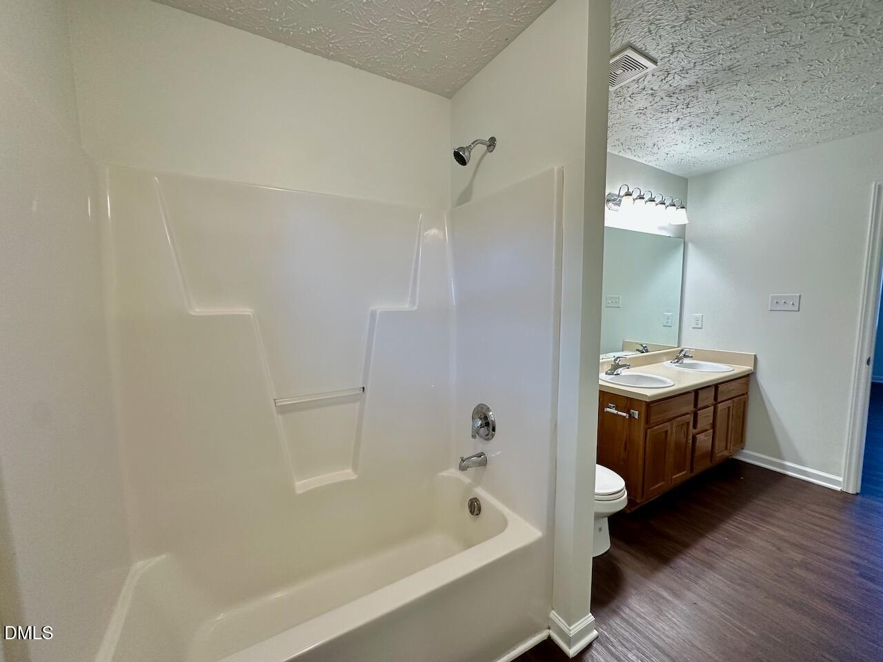 4232 Palafox Court Raleigh, NC 27604 - Photo 18 of 28 a bathroom with a tub a sink and wooden floor