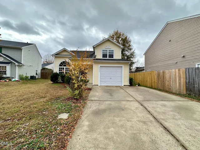 a view of a house with a yard and garage