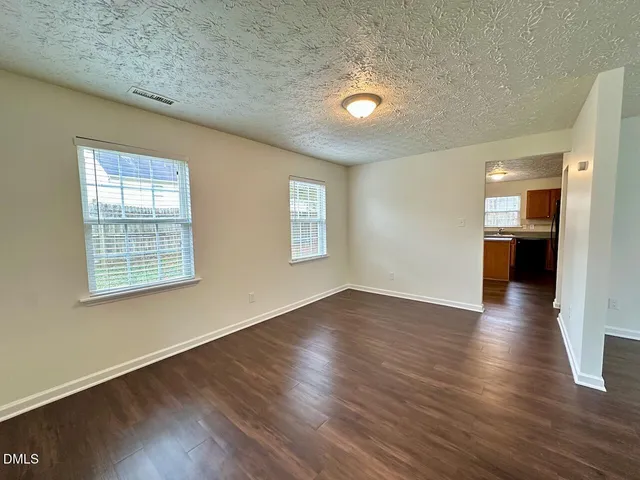 a kitchen with stainless steel appliances granite countertop a refrigerator a stove top oven and a sink with large window