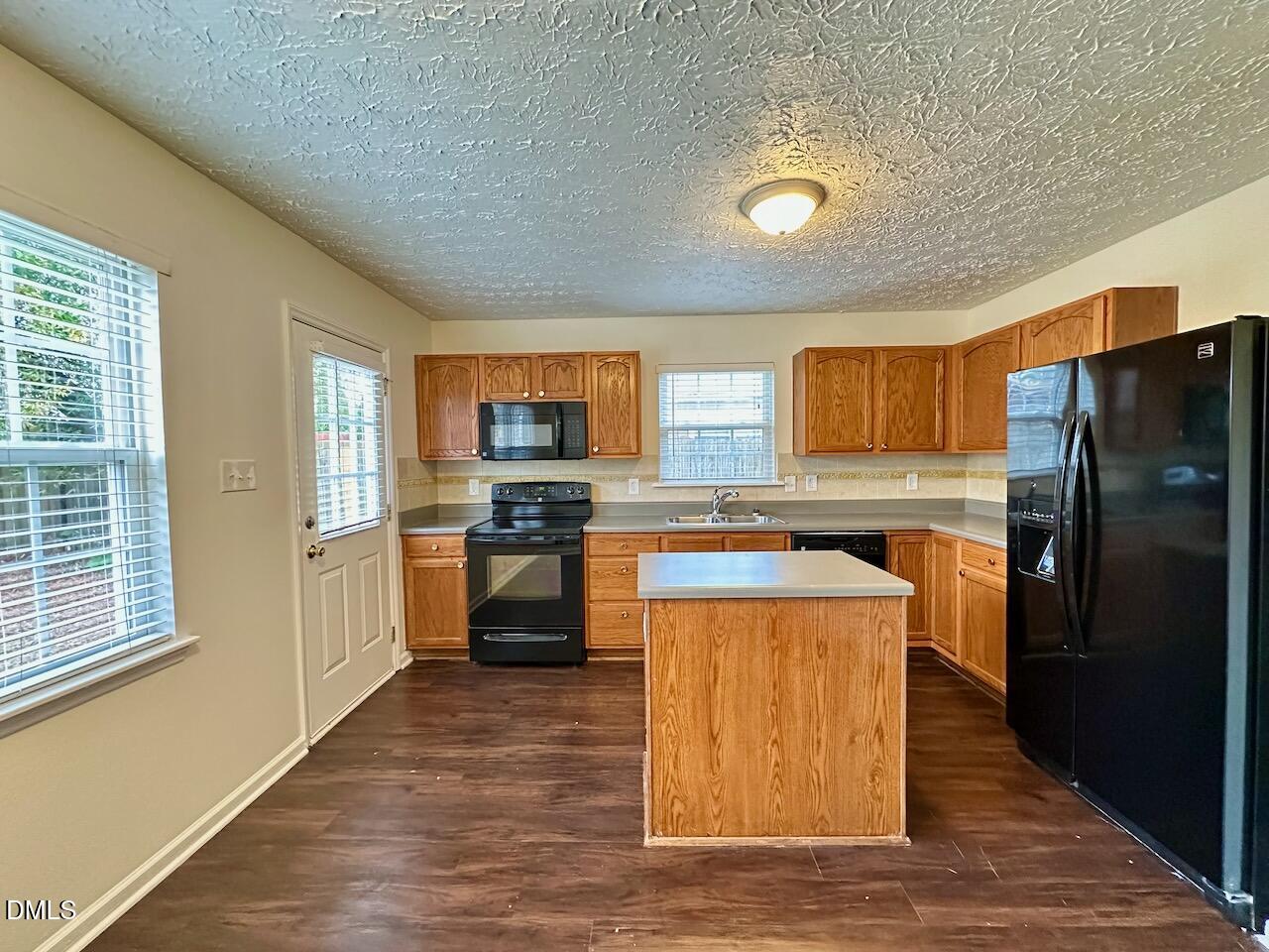 4232 Palafox Court Raleigh, NC 27604 - Photo 9 of 28 a kitchen with stainless steel appliances granite countertop a refrigerator a stove top oven and a sink with large window