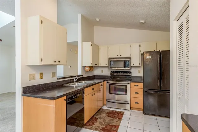 a kitchen with stainless steel appliances granite countertop a stove a refrigerator and a sink