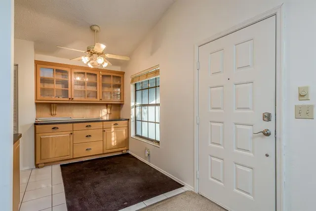 a kitchen with white cabinets and chandelier