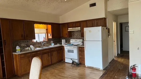 a kitchen with a refrigerator sink and cabinets