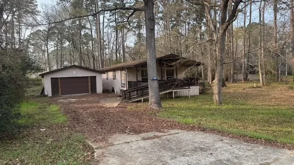 a view of a house with a yard and large tree