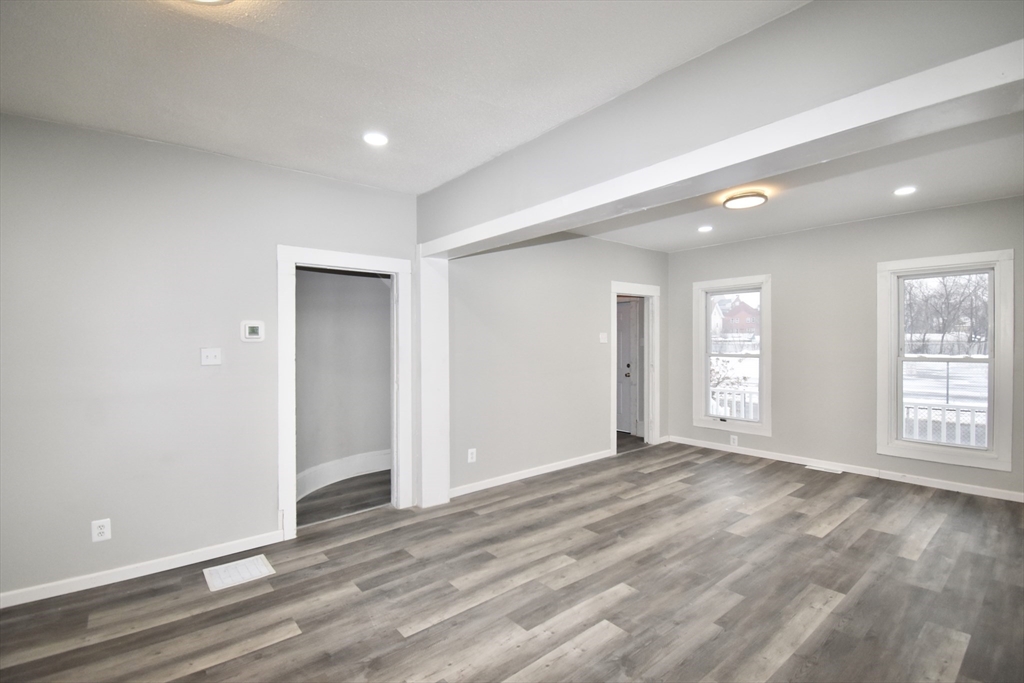 36 Orleans Street Springfield, MA 01109 - Photo 3 of 32 a view of an empty room with wooden floor and windows