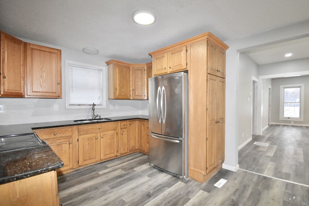 36 Orleans Street Springfield, MA 01109 - Photo 7 of 32 a kitchen with granite countertop stainless steel appliances a refrigerator a sink and cabinets