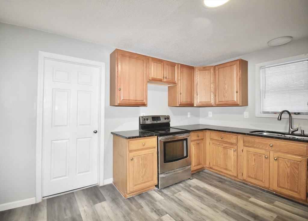 36 Orleans Street Springfield, MA 01109 - Photo 8 of 32 a kitchen with a sink cabinets and wooden floor