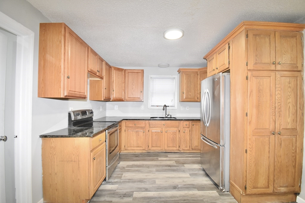 36 Orleans Street Springfield, MA 01109 - Photo 9 of 32 a kitchen with stainless steel appliances granite countertop a refrigerator and a stove top oven
