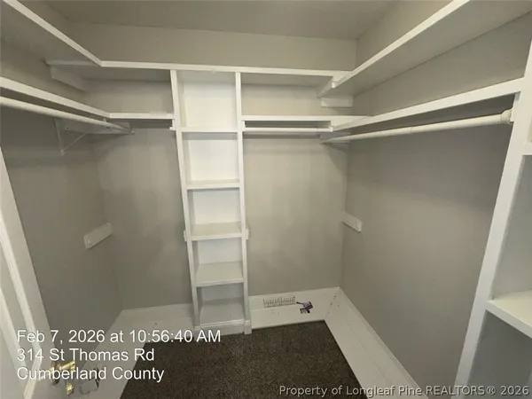 an empty room with a ceiling fan and wooden floor