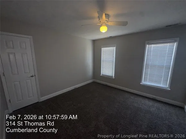 an empty room with a ceiling fan and a window