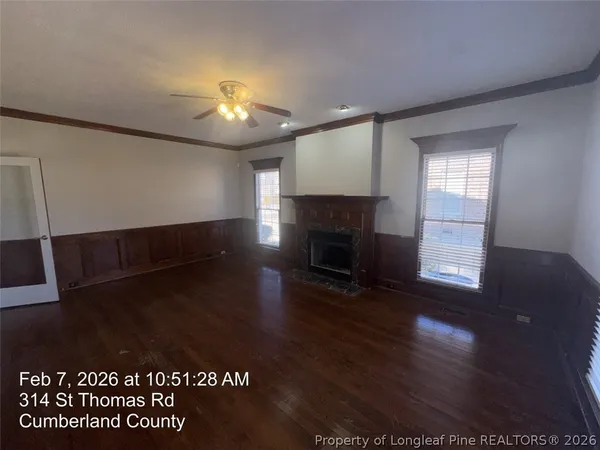 a view of empty room with wooden floor and fireplace