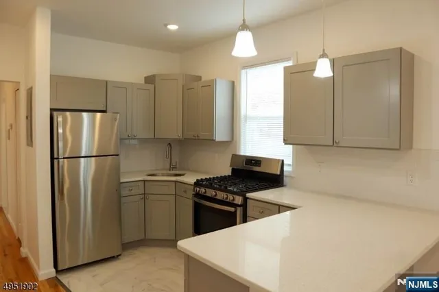 a kitchen with stainless steel appliances granite countertop a refrigerator a sink and a stove