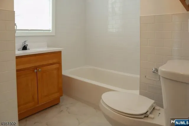 a bathroom with a granite countertop toilet and a sink
