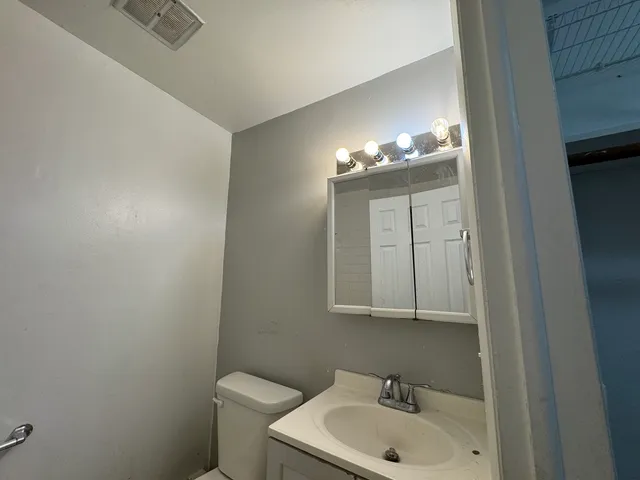 a bathroom with a toilet sink and mirror