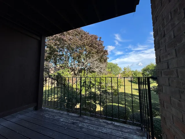 a view of a balcony with wooden floor and a bench