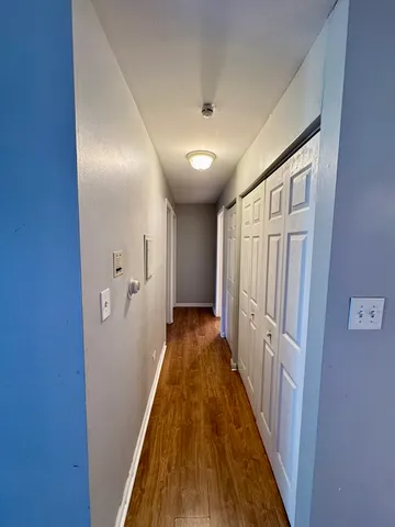 a view of a hallway with wooden floor and staircase