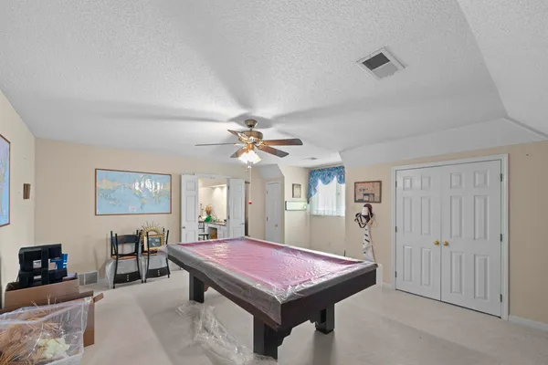a room with pool table and windows