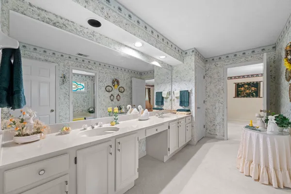 a spacious bathroom with a double vanity sink and a mirror