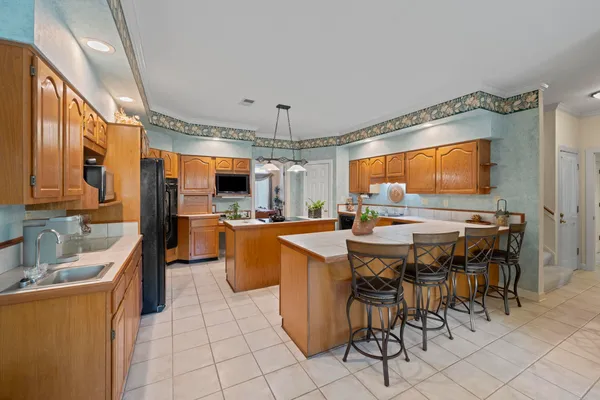 a kitchen with stainless steel appliances a table chairs and a refrigerator