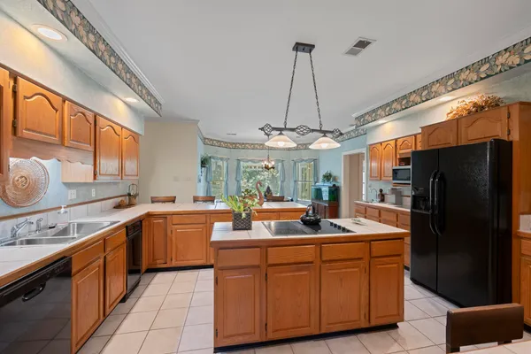 a kitchen with stainless steel appliances granite countertop a sink refrigerator and cabinets