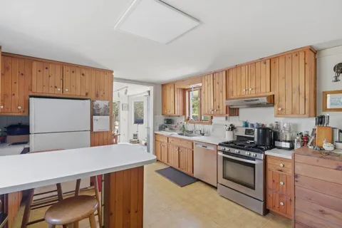 a kitchen with stainless steel appliances a stove a sink cabinets and a refrigerator